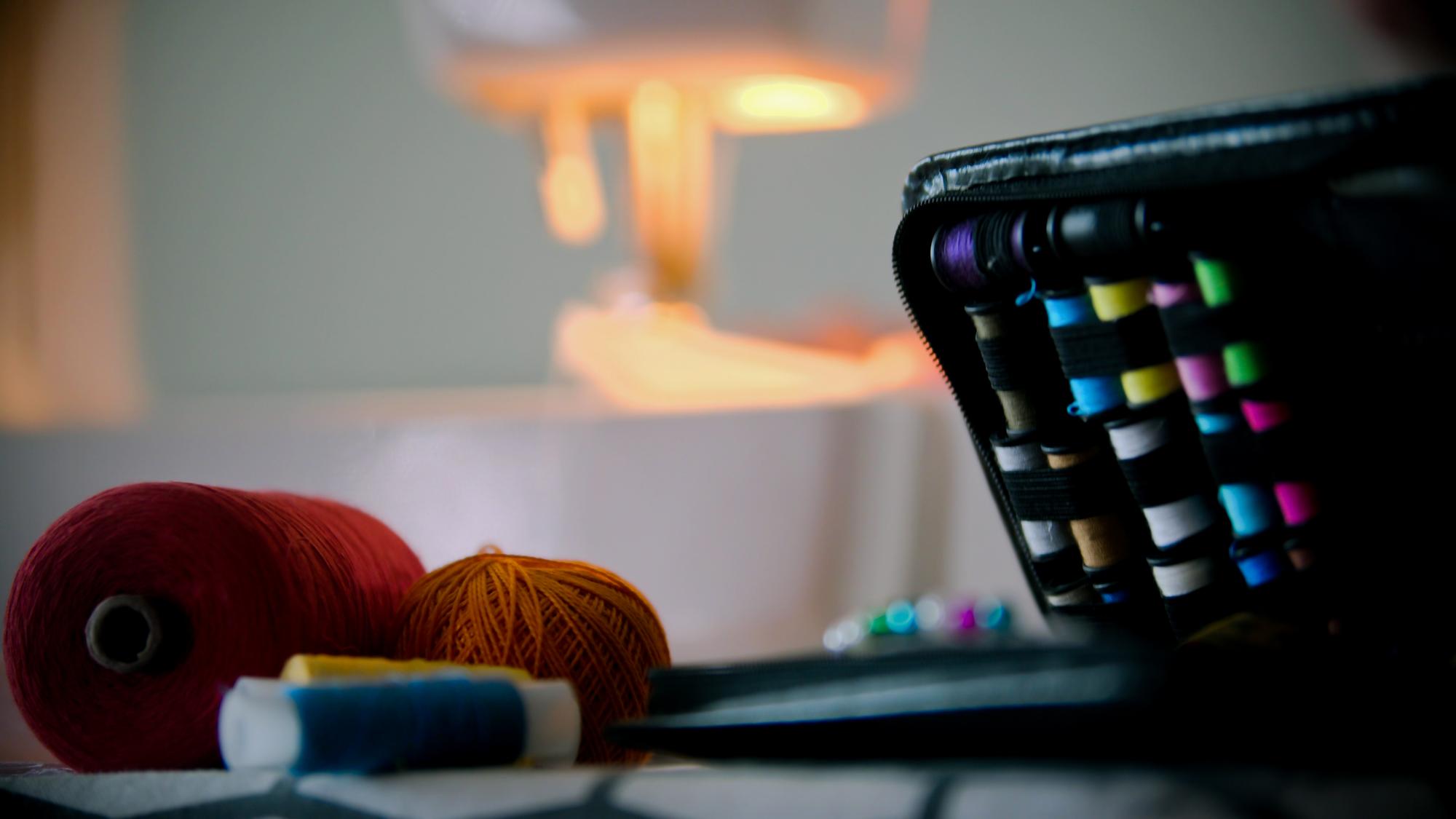 atelier workspace with spools of neon thread and a sewing machine